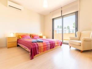 1 dormitorio con 1 cama, 1 silla y 1 ventana en Holiday Home Mestral by Interhome, en Empuriabrava