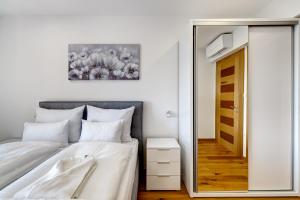 a bedroom with a white bed and a mirror at Villa Zara in Dramalj +35 photos