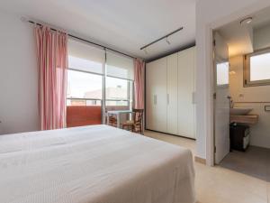 een slaapkamer met een groot wit bed en een badkamer bij Holiday Home Reig by Interhome in Cambrils