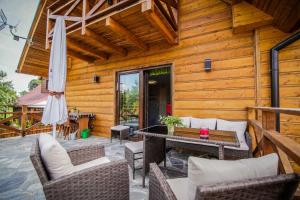 a patio with a table and chairs and an umbrella at Domek na Polance in Istebna