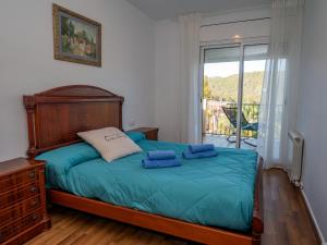 a bedroom with a bed with blue sheets and a window at Holiday Home Origin by Interhome in Olivella