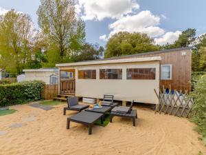 Una pequeña casa situada encima de un patio arenoso. en Holiday Home New Cottage de 2020 by Interhome, en Saint-Hilaire-de-Riez