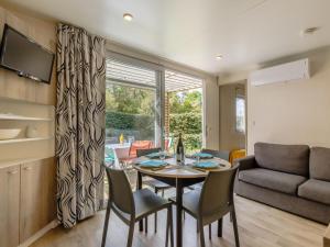 Una sala de estar con una mesa y sillas y un sofá. en Holiday Home New Cottage de 2020 by Interhome, en Saint-Hilaire-de-Riez 31 fotos más