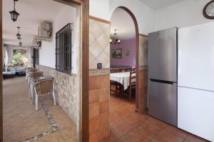 uma cozinha com um frigorífico e uma sala de jantar em Casa Rural Los Hidalgos em Totalán