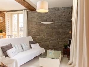 sala de estar con sofá blanco y pared de ladrillo en Apartment le Malouin by Interhome en Saint-Malo