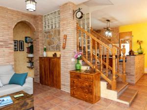 sala de estar con escalera y pared de ladrillo en Holiday Home Armonia by Interhome, en Maçanet de la Selva