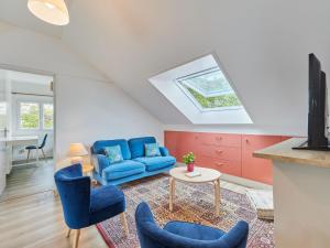 een woonkamer met een blauwe bank en een tafel bij Apartment Le laizon 2 by Interhome in Croissanville