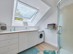 een badkamer met een wastafel en een wasmachine bij Apartment Le laizon 2 by Interhome in Croissanville