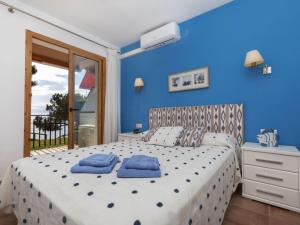 1 dormitorio azul con 1 cama con 2 almohadas azules en Apartment Cavall Bernat by Interhome en Platja  d'Aro