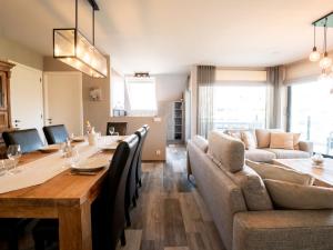 - une salle à manger et un salon avec une table et un canapé dans l'établissement Apartment Rochusview-be with parking and terrace by Interhome, à Blankenberge
