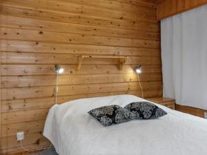 um quarto com paredes de madeira e uma cama com 2 almofadas em Holiday Home Susitupa 5 by Interhome em Salla