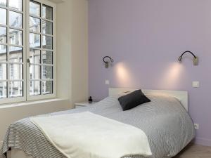 a bedroom with a bed and two windows at Apartment Plasenn by Interhome in Saint Malo