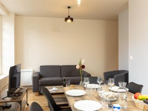 a dining room with a table and a couch at Apartment Plasenn by Interhome in Saint Malo +13 photos