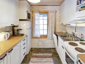 a kitchen with white cabinets and a sink and a window at Holiday Home Harvana by Interhome in Kittilä