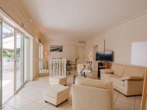 a living room with a couch and chairs and a television at Villa Les Dauphins by Interhome in Saint-Aygulf