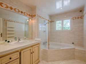 a bathroom with a tub and a sink and a shower at Villa Les Dauphins by Interhome in Saint-Aygulf