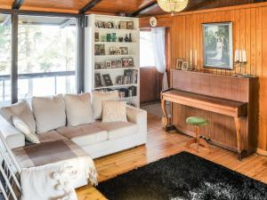 a living room with a couch and a piano at Holiday Home Pippuriranta by Interhome 