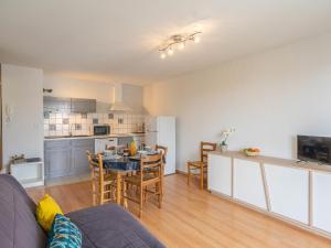 Una sala de estar con un sofá y una mesa y una cocina. en Apartment Les Hautes Folies-8 by Interhome, en Vaux-sur-Mer