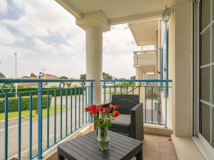 un jarrón de flores sobre una mesa en un balcón en Apartment Les Hautes Folies-8 by Interhome, en Vaux-sur-Mer