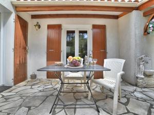 - une table et deux chaises avec un bol de fruits dans l'établissement Holiday Home Le Rocher Vert by Interhome, à Chaucre