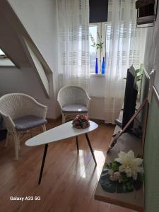 a living room with a table and two chairs at B&B Het Oude Doktershuys in Minnertsga +9 photos