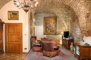 a living room with a chair and a stone wall at Hotel U Prince Prague by BHG in Prague