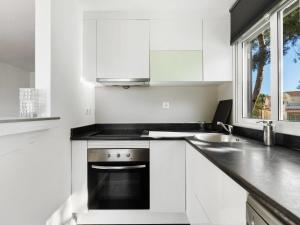 uma cozinha branca com um fogão e um lavatório em Apartment Mediterráneo by Interhome em Puerto Marino