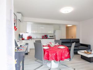 cocina y sala de estar con mesa roja y sillas en Apartment La Palmeraie II-13 by Interhome, en Sainte-Maxime