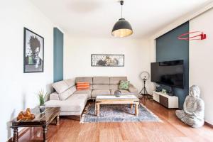 uma sala de estar com um sofá e uma televisão em Funky apartment in Zografou em Atenas