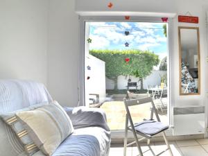 - un salon avec un canapé et une porte donnant sur une terrasse dans l'établissement Holiday Home Le Moulin de la Filasse by Interhome, à Le Trait dʼUnion