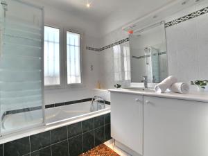 Un baño blanco con bañera y lavabo. en Holiday Home Le Moulin de la Filasse by Interhome, en Le Trait dʼUnion