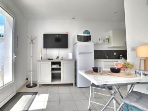 Una cocina con un refrigerador blanco y una mesa. en Holiday Home Le Moulin de la Filasse by Interhome, en Le Trait dʼUnion