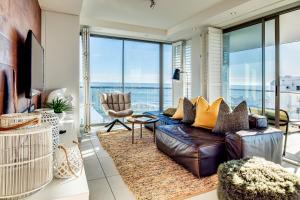 sala de estar con sofá y vistas al océano en Fairmont 1001, en Ciudad del Cabo