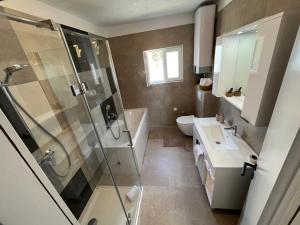 a bathroom with a shower and a sink and a toilet at Apartments Kale Center in Bol