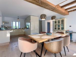 a kitchen and dining room with a wooden table and chairs at Holiday Home Villa Anita by Interhome in Momjan