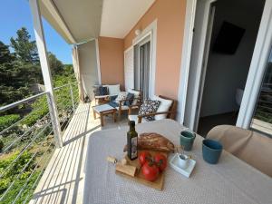 uma mesa com uma garrafa de vinho e fruta numa varanda em Apartments Kale Center em Bol