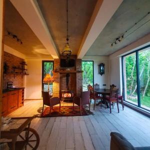 a living room with a table and a fireplace at Villa Vejini in Mamkoda