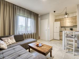 a living room with a couch and a table and a kitchen at Apartment Ani by Interhome in Kastav