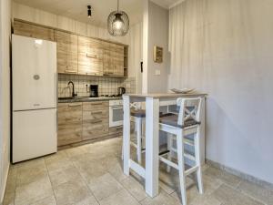 a kitchen with a white refrigerator and a table and stool at Apartment Ani by Interhome in Kastav