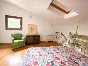 a bedroom with a bed and a green chair at Apartment Orcagna apartment by Interhome in Florence