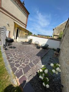 a patio with two chairs and a grill in a yard at Maison ancienne très lumineuse axe Reims / Laon 