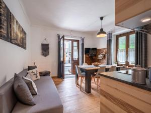 eine Küche und ein Wohnzimmer mit einem Sofa und einem Tisch in der Unterkunft Apartment Il Fior di Neve by Interhome in Prali