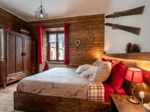 1 dormitorio con 1 cama y 1 sofá rojo en Apartment Il Fior di Neve by Interhome, en Prali