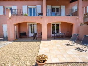 a building with a patio with chairs and tables at Holiday Home Villa Clair de Lune by Interhome in Hyères