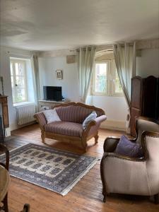 salon z kanapą i 2 krzesłami w obiekcie La Villa Romaine w mieście Montmirey-la-Ville
