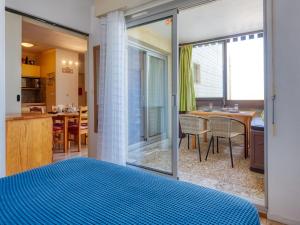 a bedroom with a blue bed and a kitchen at Apartment Les Terrasses de l'Atlantique-7 by Interhome in Lacanau-Océan +25 photos