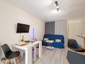 sala de estar con mesa blanca y sofá azul en Apartment Le Riviera-3 by Interhome, en Saint-Aygulf