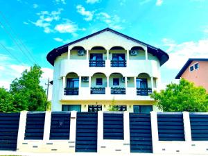 奥托佩尼Vila Zoe BucharestAirport&Therme&Parking Otopeni的一栋前面有栅栏的白色房子