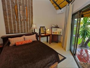 Un dormitorio con una cama grande y una ventana. en La Rochelle Lodge Namibia Tsumeb, en Tsumeb 48 fotos más