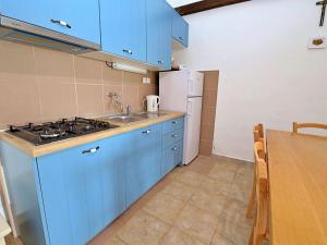 a kitchen with blue cabinets and a sink and a table at Holiday Home Micheli by Interhome in Gornji Humac